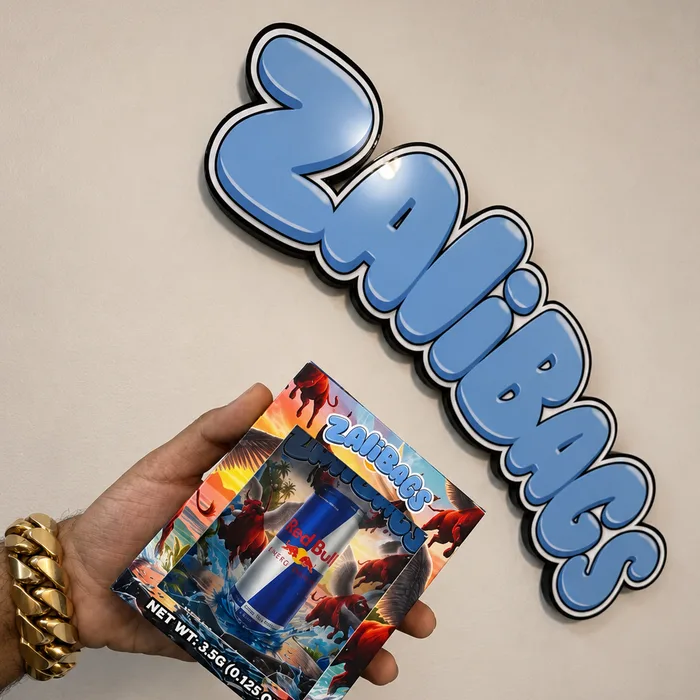 A pale blue ZALIBAGS bubble-letter sign on a wall, with a hand holding a matching printed pouch below it